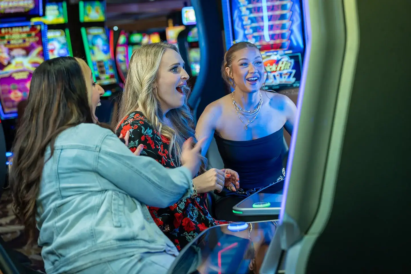Women enjoying playing slot machines together