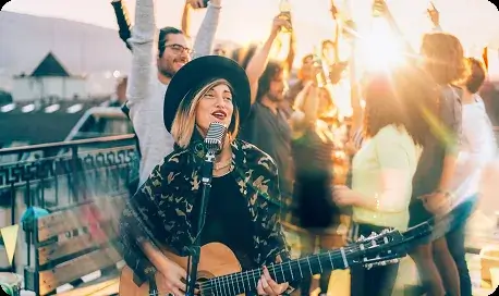 Musician playing guitar at outdoor party with friends