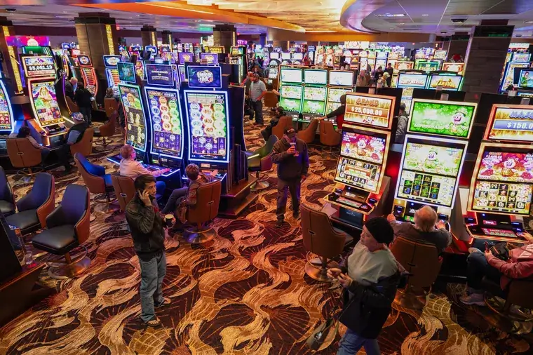 People playing slot machines in a busy casino